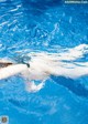 A person swimming in a pool with water splashing around them.