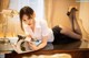 A woman laying on top of a desk reading a book.