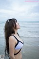 A woman in a bikini standing on the beach.