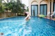 A woman in a green bikini standing in a swimming pool.