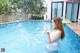 A woman in a white bikini standing in a swimming pool.