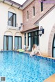 A woman sitting on the edge of a swimming pool.