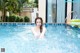 A woman in a swimming pool with an inflatable raft.