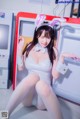 A woman in a bunny costume sitting in front of a refrigerator.