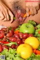 A woman is eating a bunch of fruits and vegetables.
