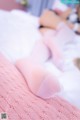 A woman laying on a bed with pink socks.