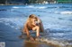 A woman in a white bikini laying in the water.