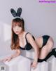 A woman in a black lingerie with bunny ears on her head.