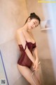 A woman in a red lingerie is taking a shower.