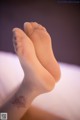 A close up of a person's feet with a tattoo on their leg.