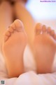 A close up of a person's feet on a bed.