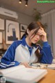 A woman sitting at a desk with her head in her hands.