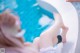 A woman laying on the edge of a swimming pool with her feet up.