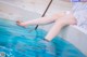 A woman sitting on the edge of a swimming pool.