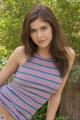 A young woman in a striped dress posing for a picture.