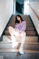 A woman sitting on the steps of a building.