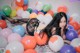 A woman laying on the floor surrounded by balloons.