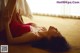 A woman in a red lingerie laying on the floor.