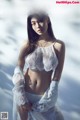 A woman in a white lingerie posing in the snow.