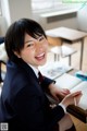 A young woman sitting at a desk in a classroom.