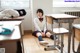 A woman sitting on the floor in a classroom.