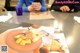 A woman sitting at a table with a plate of food on it.