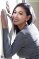 A woman leaning against a wall with her hand on the wall.