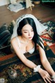 A woman in a wedding dress laying on a rug.