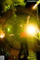 A woman holding a sparkler in front of a clock.