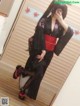 A woman in a black and red kimono taking a selfie.