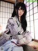 A woman in a kimono sitting on a window sill.