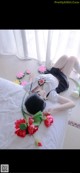 a woman laying on top of a bed covered in flowers