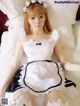 A woman in a maid outfit laying on a bed.