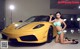 A woman in a bikini posing next to a yellow sports car.