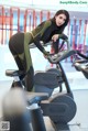 A woman on a stationary bike in a gym.