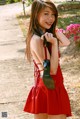 A woman in a red dress holding a pair of shoes.