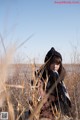 A woman sitting in a field of tall grass.