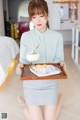 A woman holding a tray with food on it.