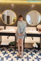 A woman standing in front of two sinks in a bathroom.