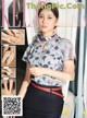 a woman in a blue shirt and black skirt posing for a magazine