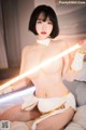 A woman in a white and gold outfit holding a light saber.