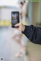 A person taking a picture of a woman in a black jacket.