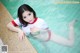 A woman in a red and white shirt is sitting in a pool.