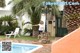 A woman standing next to a swimming pool in a backyard.