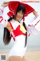 A woman in a red and white outfit on the beach.