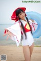 A woman in a white bathing suit holding an inflatable ring.