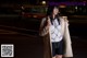 A woman standing in the middle of a street at night.