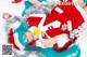 A woman in a santa claus outfit laying on the snow.