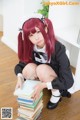 A woman in a maid outfit sitting on a pile of books.