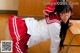 A woman in a red and white uniform is posing for a picture.